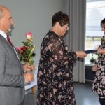 Wójt i kierownik GOPS wręczają pracownicy GOPS różę i okolicznościowe podziękowanie