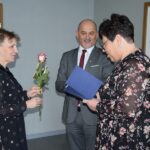 Wójt i kierownik GOPS wręczają pracownicy GOPS różę i okolicznościowe podziękowanie