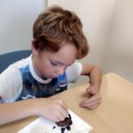 Chłopiec dekoruje czekoladową babeczkę