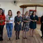 Sześć kobiet, jedna z nich - prezes stowarzyszenia trzyma w ręku kwiaty