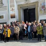 Kilkudziesięcioosobowa grupa uczestników wycieczki stoki przed bazyliką w Wadowicach