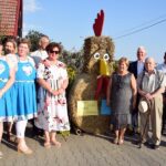 Organizatorzy dożynek w Szemborowie przy dożynkowej ozdobie ze zboża w kształcie koguta