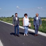 Wójt, przewodniczący Rady Gminy i radna z okręgu Szemborowo rozmawiają spacerując po nowej drodze