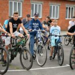 Grupa młodych chłopców na rowerach czeka na start rajdu