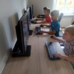 Czwórka dzieci w sali komputerowej podczas gry