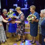 Członkowie zarządu SSOSiN wręczają kwiaty i listy gratulacyjne jubilatkom obchodzącym 80. urodziny