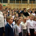 Uczniowie stoją na baczność podczas śpiewania hymnu