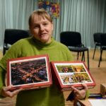 Kobieta prezentuje dwa zestawy wylicytowanych puzzli