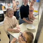 Dzieci podczas wygniatania ciasta na pizzę