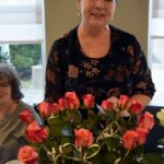 Uśmiechnięta kobieta trzyma wazon z różami