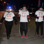 Trzy kobiety z kijkami do Nordic Walking wchodzą na metę