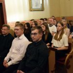 Ludzie siedzący w kościelnych ławkach oglądają film o kościele w Graboszewie