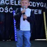 Chłopiec na scenie śpiewa do mikrofonu