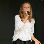 Nastolatka na scenie śpiewa do mikrofonu