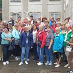 Kilkudziesięciu uczestników wycieczki do Warszawy pozuje do wspólnego zdjęcia