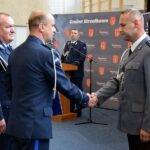 Zastępca komendanta wojewódzkiego policji gratuluje awansowanemu funkcjonariuszowi