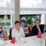 Cztery uśmiechnięte kobiety siedzą za stołem