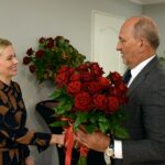 Wójt wręcza kierownik GOPS bukiet czerwonych róż