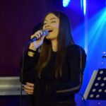 Młoda wokalistka śpiewa do mikrofonu