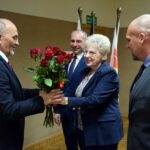Wiceprzewodnicząca Rady Gminy Strzałkowo wręcza wójtowi bukiet czerwonych róż. Obok stoi przewodniczący rady i drugi zastępca