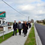 Przedstawiciele gminy, powiatu i wykonawcy spacerują po nowym chodniku