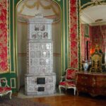 Komnata w pałacu z wielkim lustrem i zdobionym piecem kaflowym