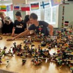 Kilkoro chłopców na stole układa klocki lego