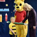 Zastępca dyrektora ZSP Strzałkowo za pomocą wielkiego ołówka dokonuje pasowania chłopca