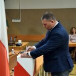 Radny Marek Hejna oddaje głos wrzucając kartę do biało-czerwonej urny