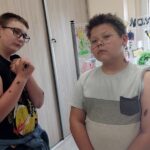 Dwóch chłopców prezentuje wykonane przez siebie naklejane tatuaże m.in. w kształcie pająków