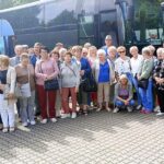 Wspólne zdjęcie kilkudziesięciu uczestników wycieczki przy autobusie