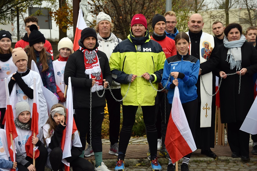 Wójt i starosta toją w grupie uczniów i trzymają w rękach rozerwany łańcuch