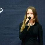 Dziewczyna śpiewa piosenkę do mikrofonu