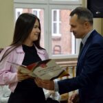 Wójt wręcza stypendystce z ZSP Strzałkowo teczkę z dyplomem