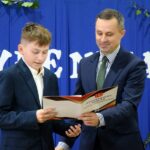 Wójt wręcza stypendyście z ZSP Strzałkowo dyplom w teczce