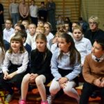 Dzieci siedzą na ławeczkach w sali ZSP Wólka
