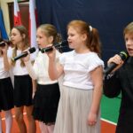 Dzieci śpiewają do mikrofonów podczas występu